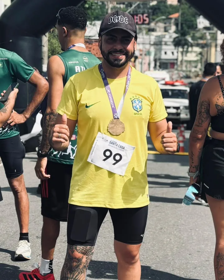 Igor sorrindo com medalha no peito ao fim de uma prova de corrida de rua